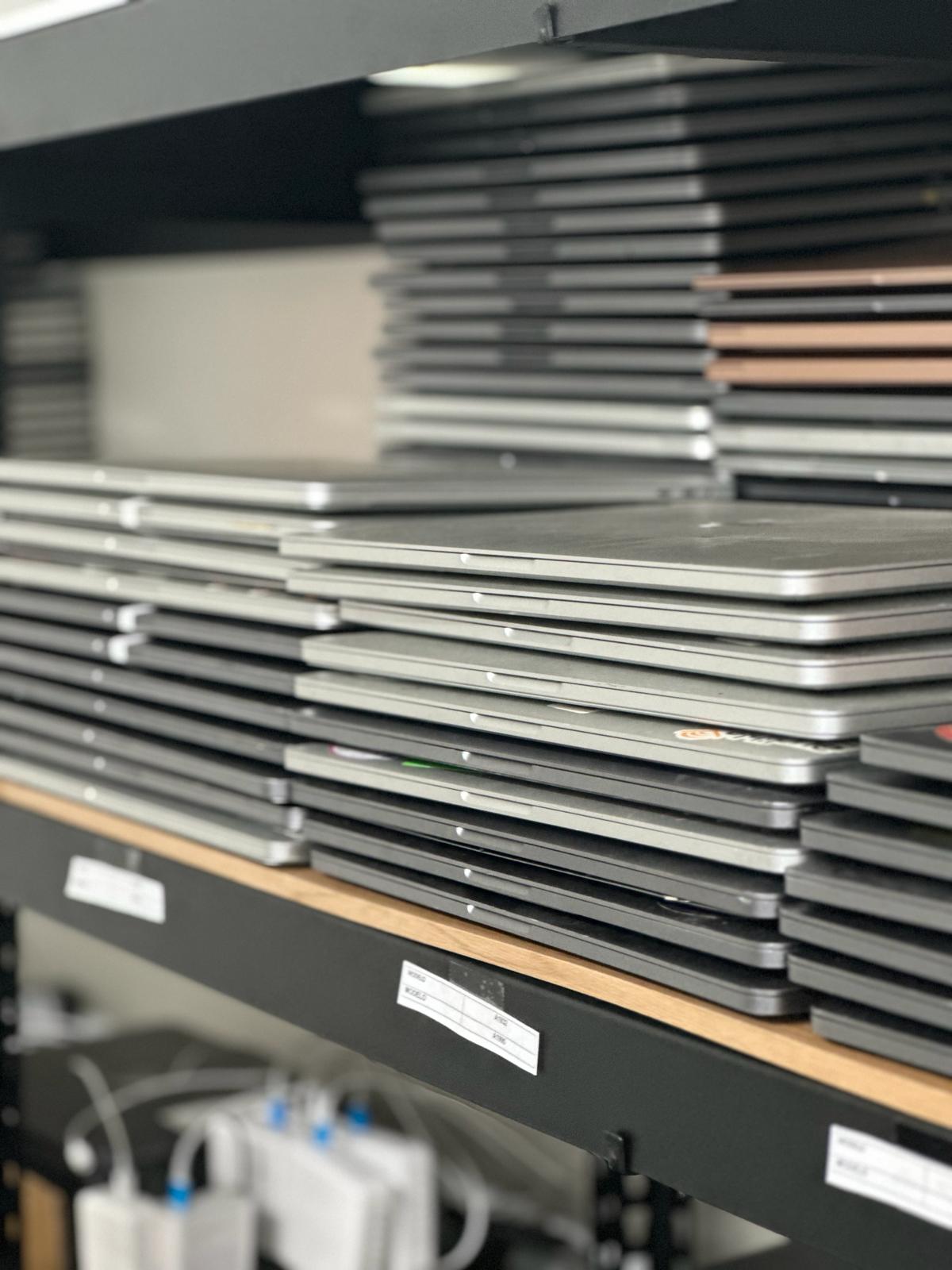 Stacked laptops on a shelf