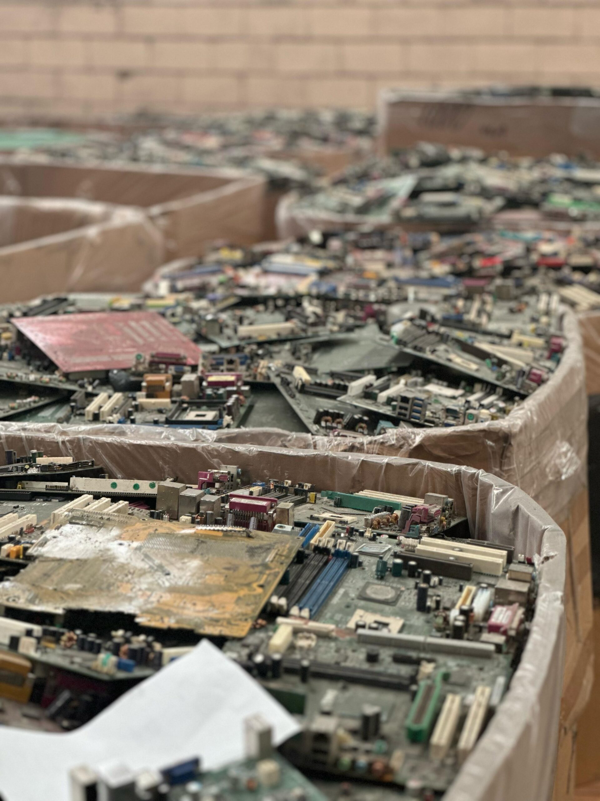 A pile of discarded computer motherboards in a warehouse.